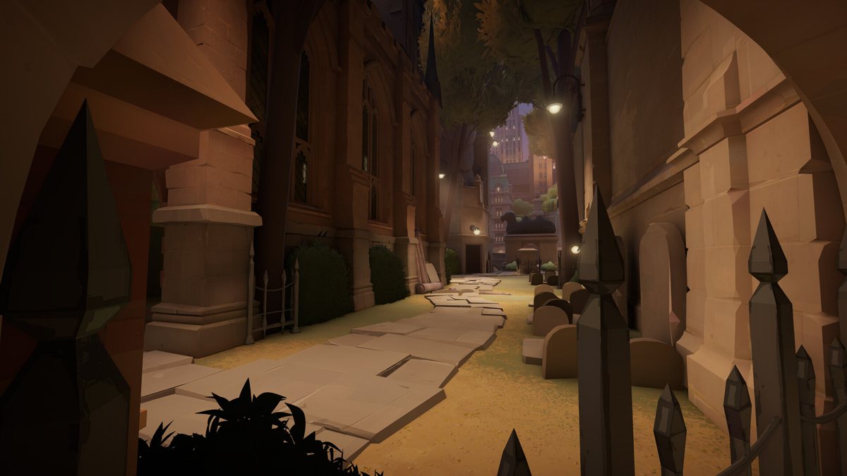 Capture officielle de Deadlock : une ruelle sombre bordée de pierres tombales et de grilles, avec une ligne de vue étroite qui débouche sur la ville éclairée au fond