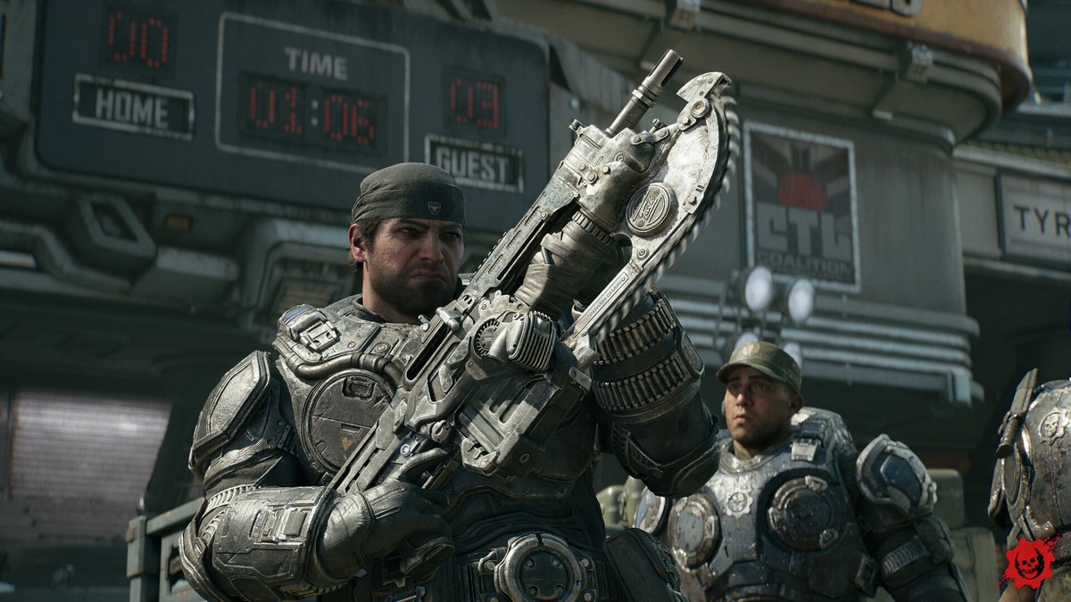 Capture officielle de Gears of War: E-Day : Marcus Fenix tient son Lancer à baïonnette tronçonneuse devant un tableau d'affichage de stade, avec un coéquipier en arrière-plan