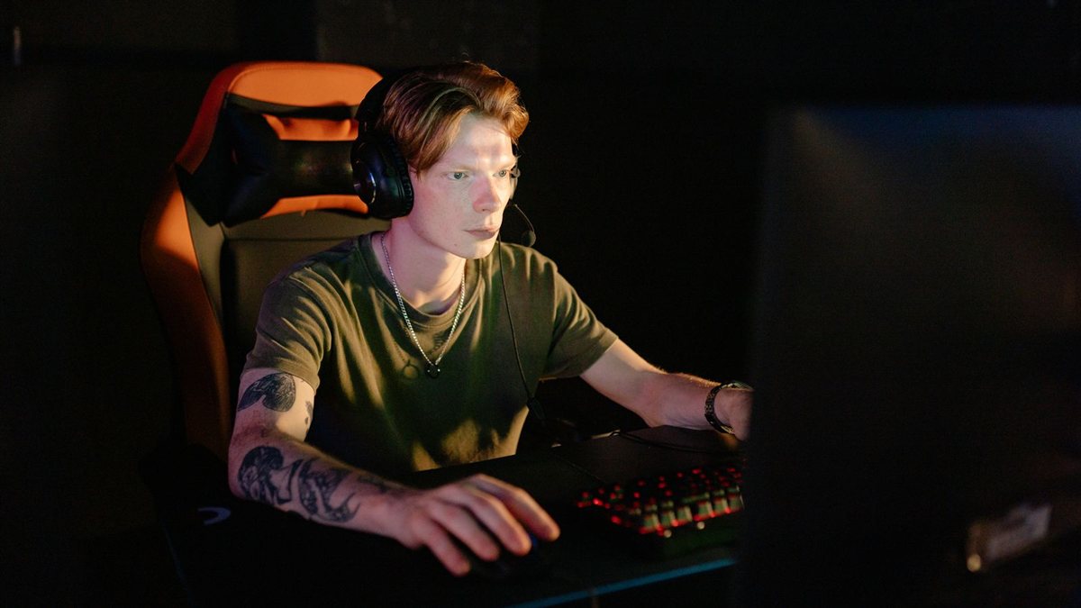 Jeune joueur concentré avec un casque devant son écran, en pleine partie