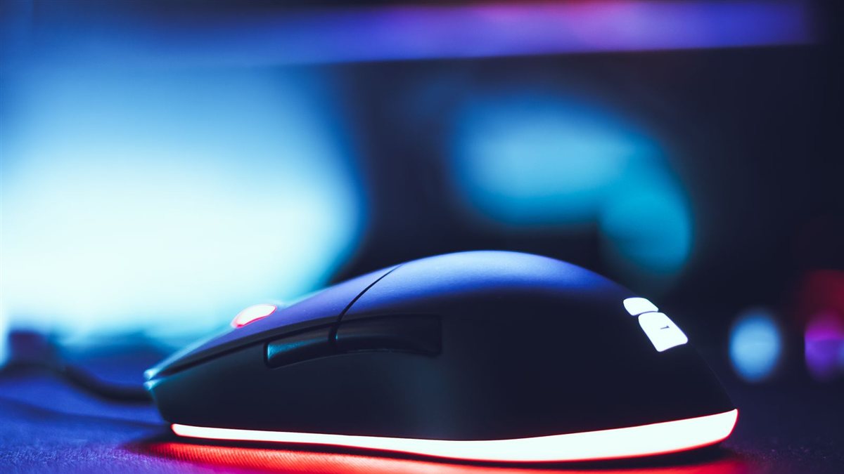 Photo d'illustration : gros plan sur une souris gaming éclairée par des LED, avec le bouton de clic qui sert à déclencher le tir en jeu
