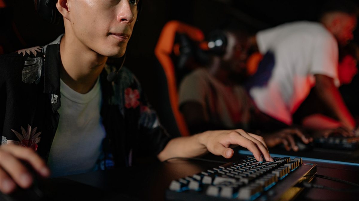 Salle de tournoi esport en LAN avec les postes des joueurs alignés et éclairés, ambiance de compétition