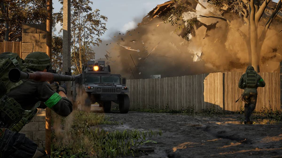 Capture officielle de WARDOGS : un soldat épaule un lance-roquettes près d'un véhicule blindé pendant qu'une maison explose en projetant des débris
